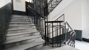 Una escalera con barandillas y pasamanos, que lleva a un piso superior.