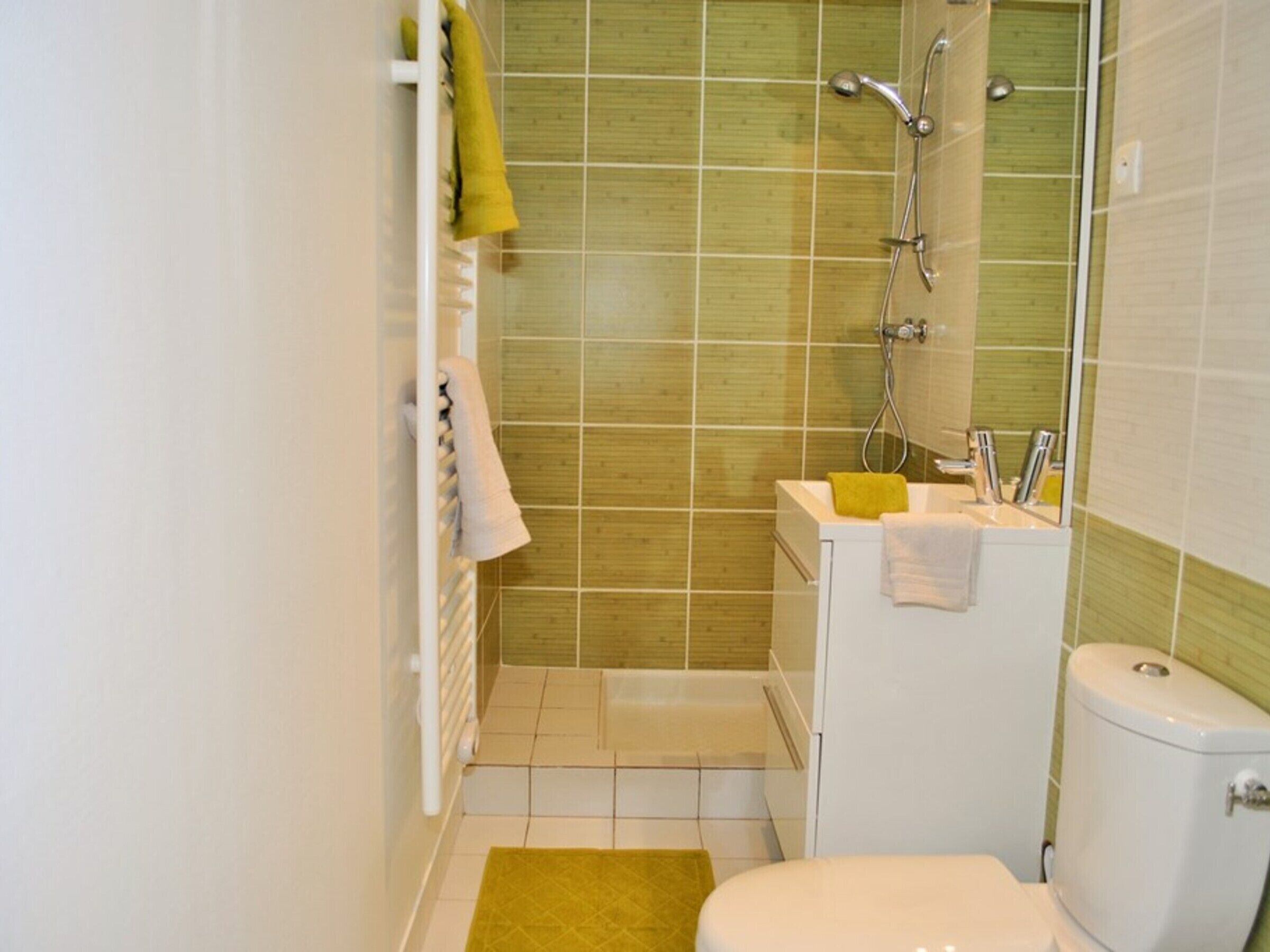 Un baño pequeño con inodoro, lavamanos y ducha.