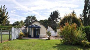 Ein kleines, eingeschossiges Haus mit blauer Tür und einer kleinen Veranda.