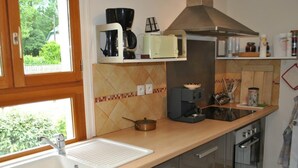 Eine Küche mit Spüle, Herd, Mikrowelle und Kaffeemaschine.
