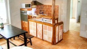 Una cocina compacta con microondas, horno y lavamanos.