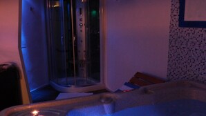 A hot tub with a glass enclosure and a candle. - Boutique & spa Sirenahotel (Gabicce Mare)