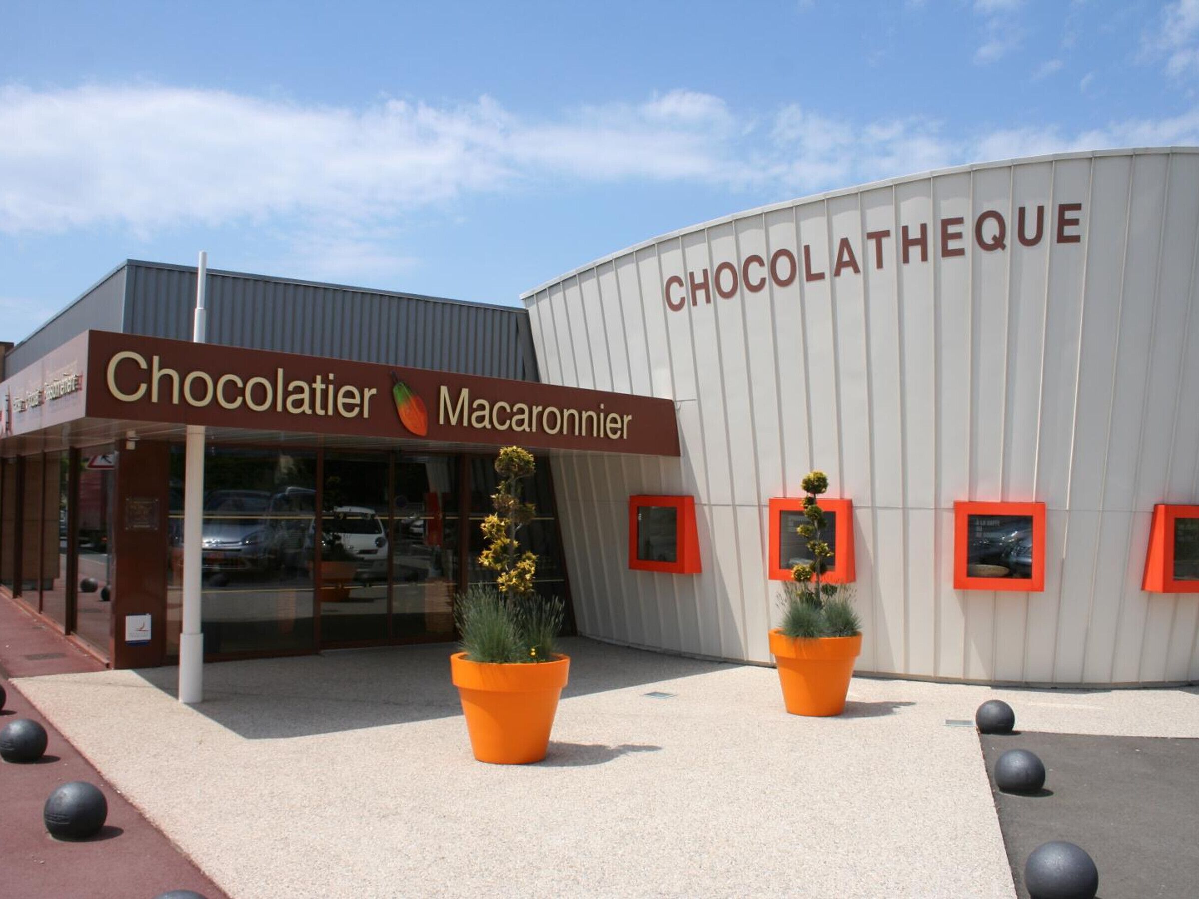 A building with a sign reading "Chocolatier Macaronnier" and another sign on the side that says "CHOCOLATHEQUE".
