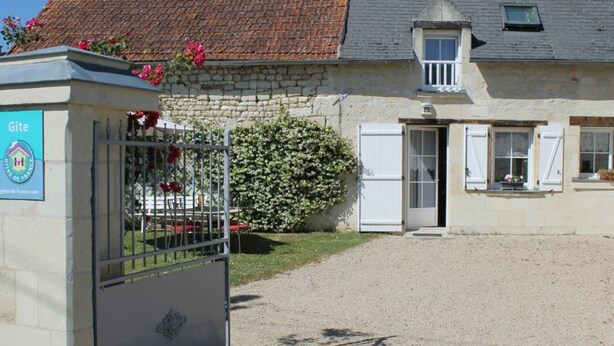 A stone building with a tiled roof, a gated entrance, and a small window. - Charming Tufa Stone Cottage with Courtyard, Near Loire Castles, Electric Bike Rental Available (Savigny-en-Véron)