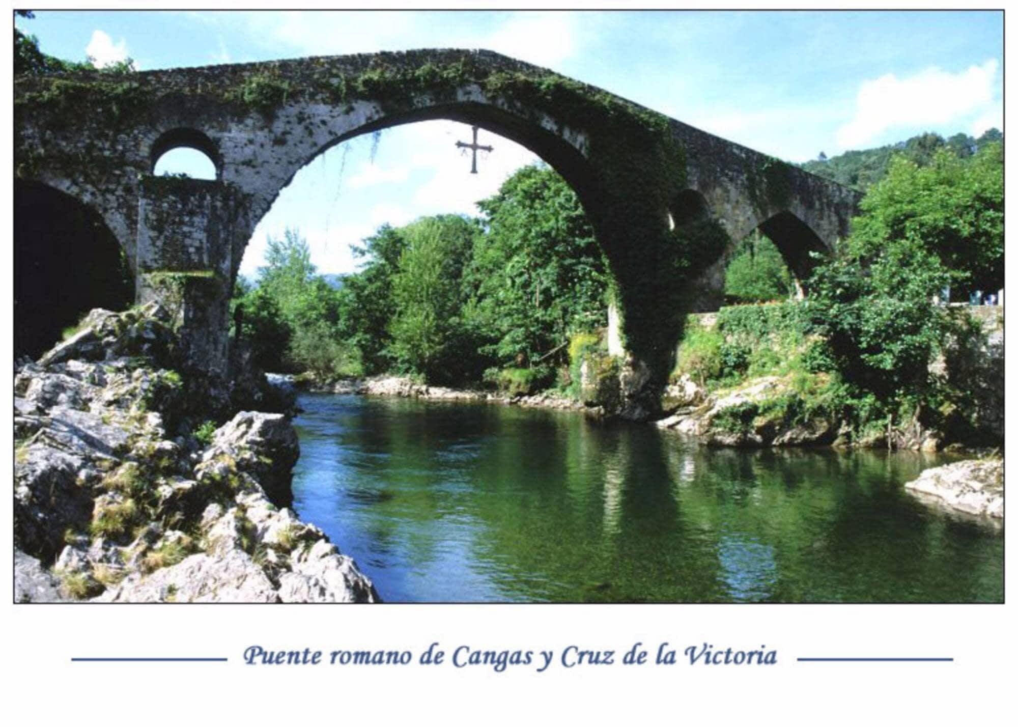 Un puente romano de piedra con arcos sobre un río, rodeado de vegetación.