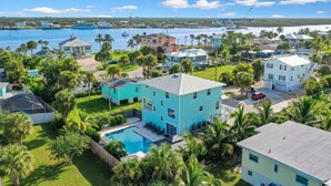 Un quartier résidentiel avec des maisons, une piscine et, au loin, un port de plaisance.