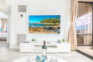 Relax in this inviting living room with a stunning coastal view, a console table, and a beautiful painting.