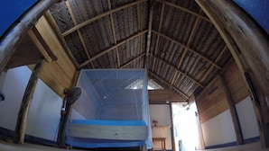 A room with a high, sloped wooden ceiling and a large bed with a blue mattress. - Safasurf Camp - Hostel (Arugam Bay)