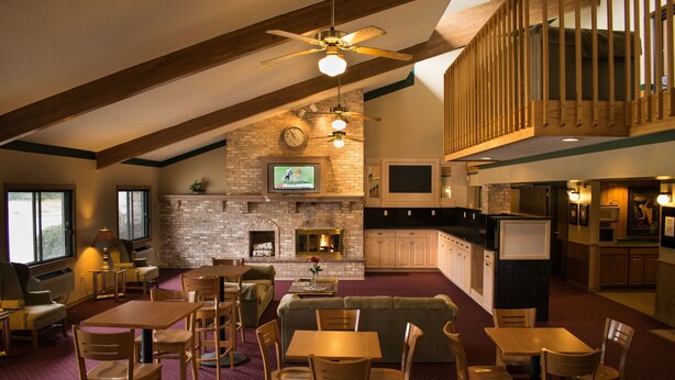 A spacious living area with a fireplace, dining area, and kitchen. - Odisha House of Rest (Shawano)