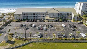 A hotel with a parking lot, a pool, and a view of the ocean. - 314- BEACH FRONT, gulf view, family-friendly! Destin Beach Club (Destin)