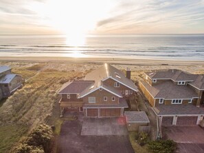 Zona residencial costera con casas, una carretera y una playa al fondo.