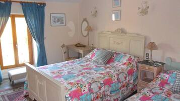 Un dormitorio con una cama, un escritorio y una silla.