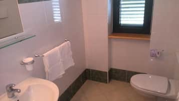 Un bagno con lavandino, WC e finestra.