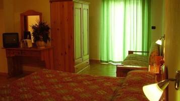 Ein Zimmer mit Bett, Schreibtisch, Kleiderschrank und Fernseher.