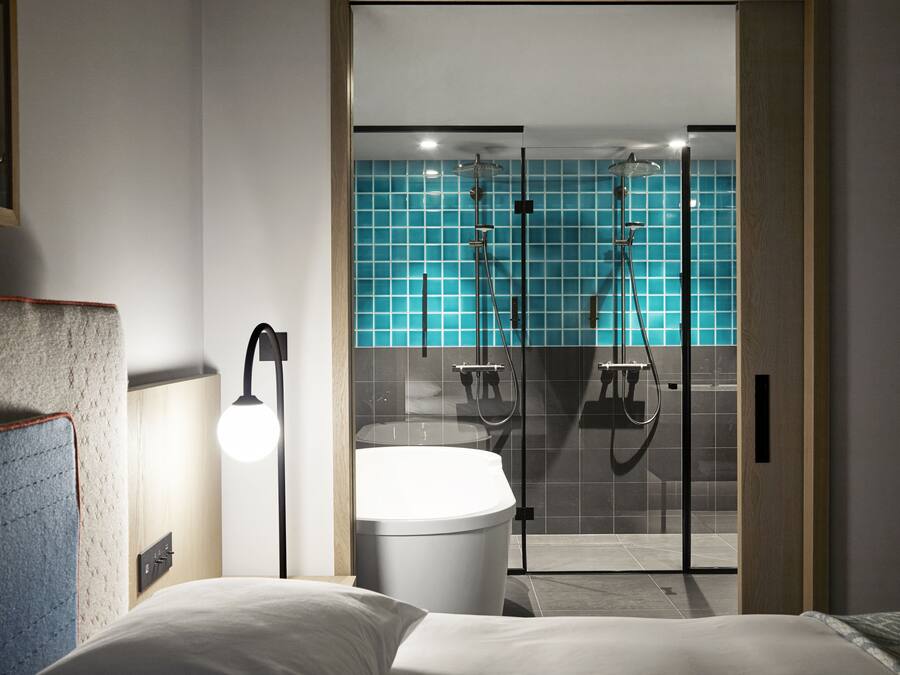 A modern bathroom with a glass shower enclosure, a white sink, and a large bathtub.