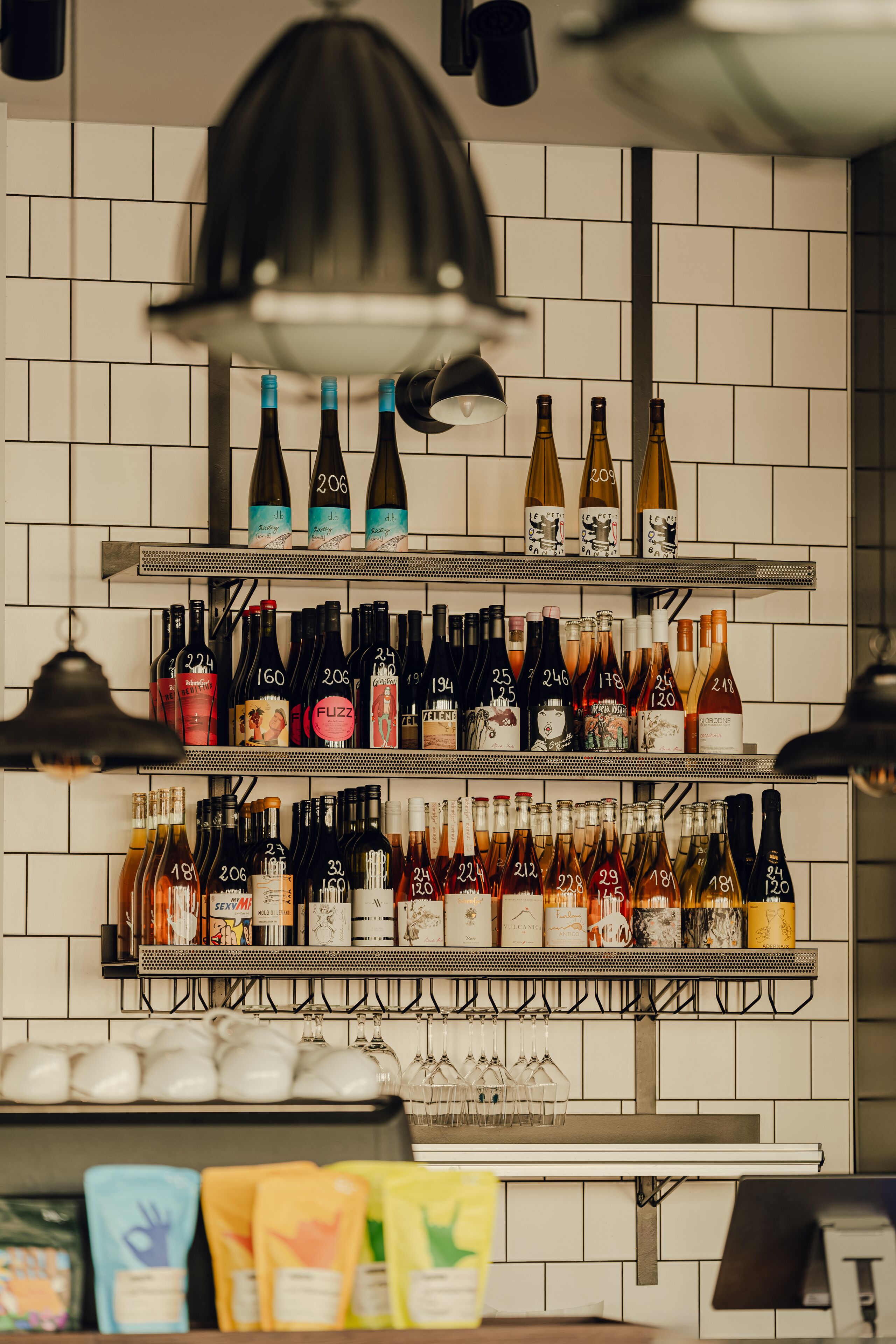 A wine rack with various bottles and glasses.