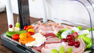 Una bandeja con una variedad de productos delicatessen como embutidos, quesos y verduras.