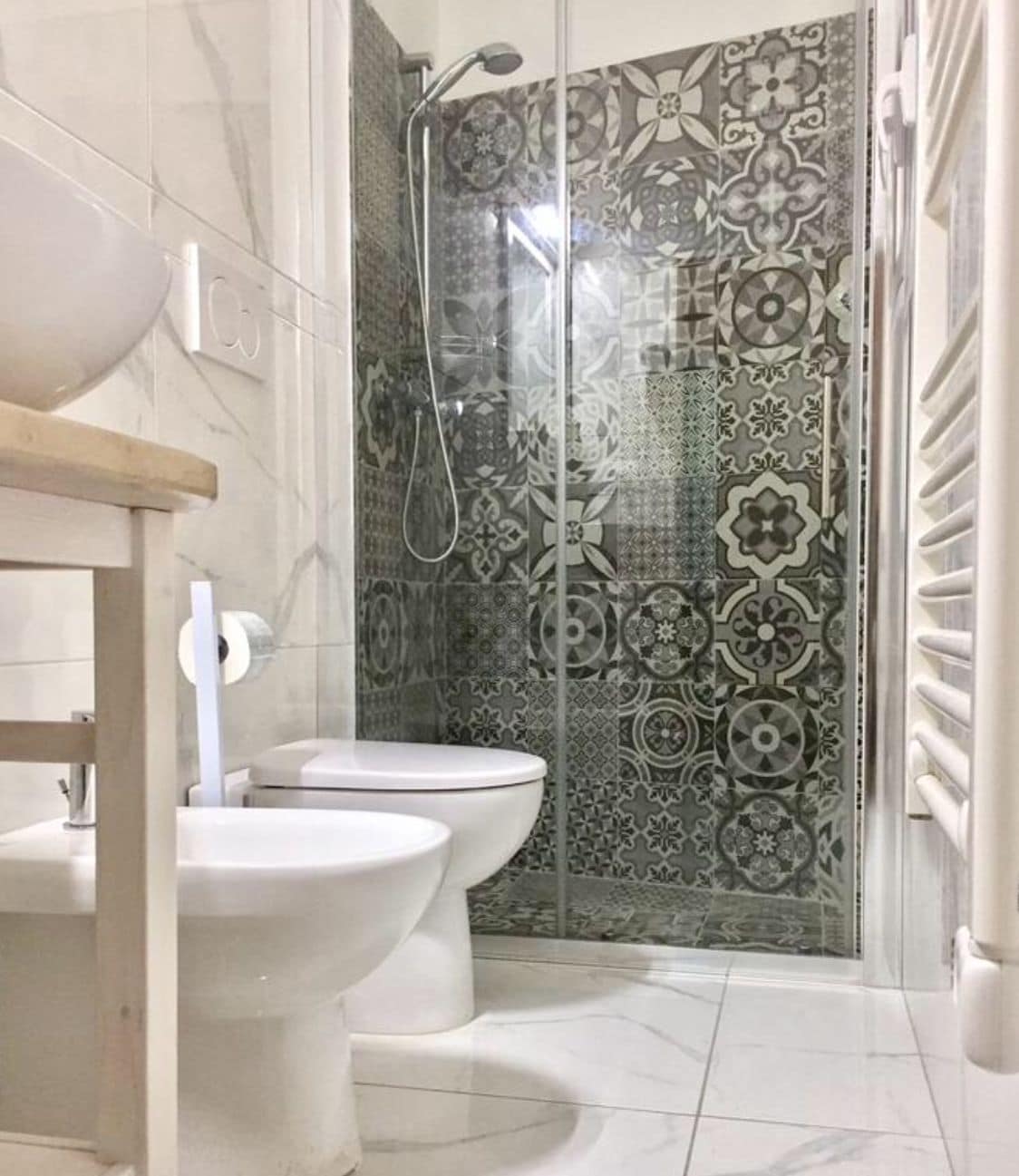 A bathroom with a shower, two toilets, and a sink.