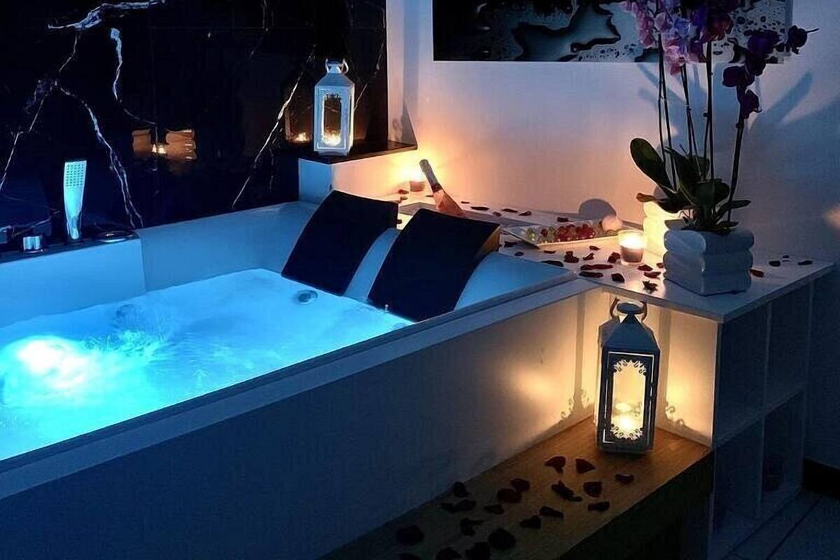 Ein modernes Badezimmer mit einer großen Badewanne, einer Marmorwand und einem Blumenbild.