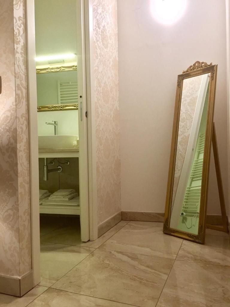 Un baño con tocador, espejo y perchero.