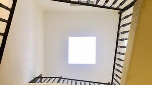 A corner of a room with a white wall and a black metal staircase railing. - Dimora San Biagio Suites & Apartment (Lecce)
