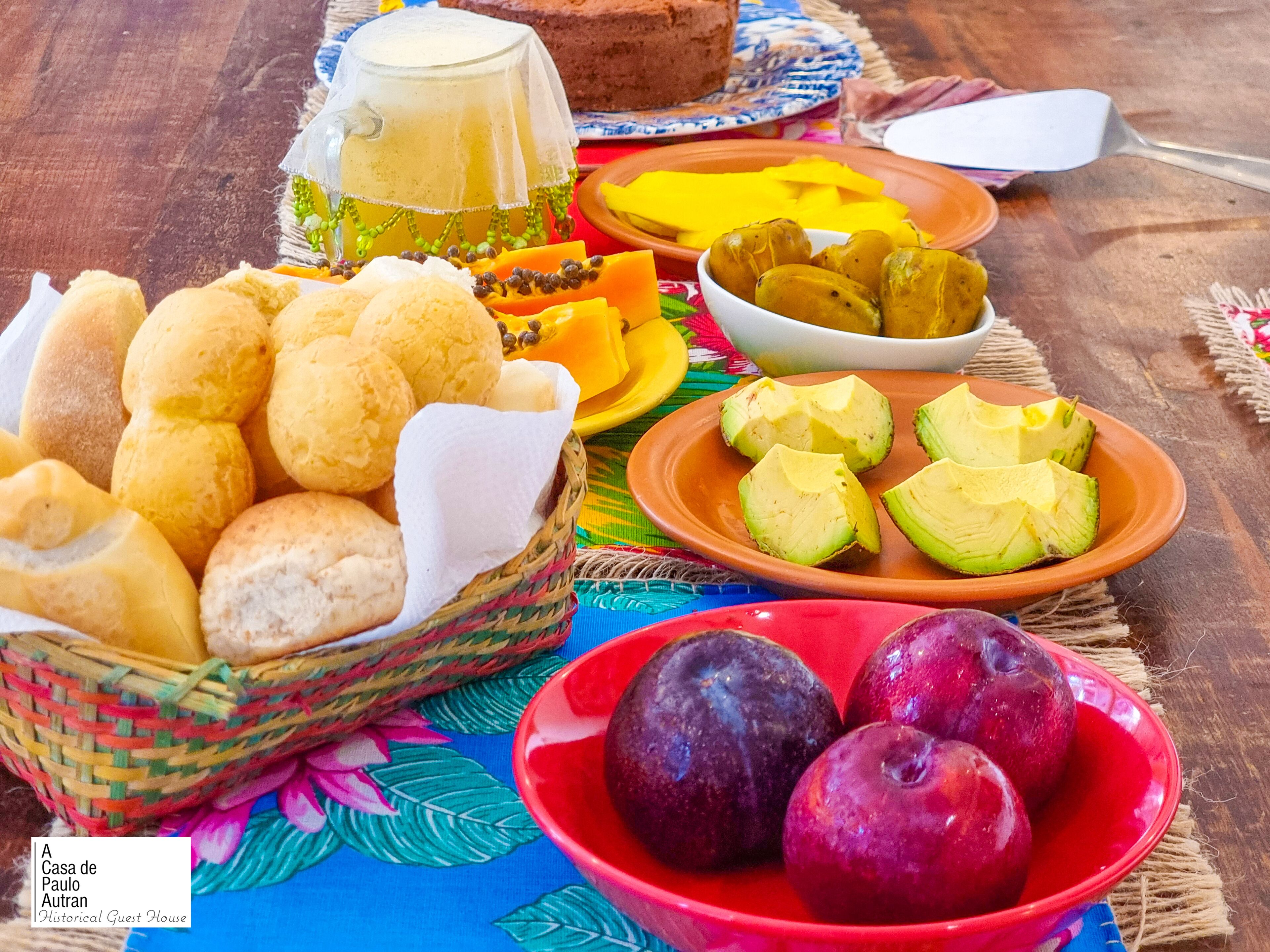 A table with various food items including bread, avocado, and plums.