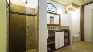 Een badkamer met douche, toilet en wastafel.