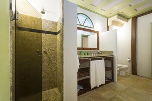Een badkamer met douche, toilet en wastafel.