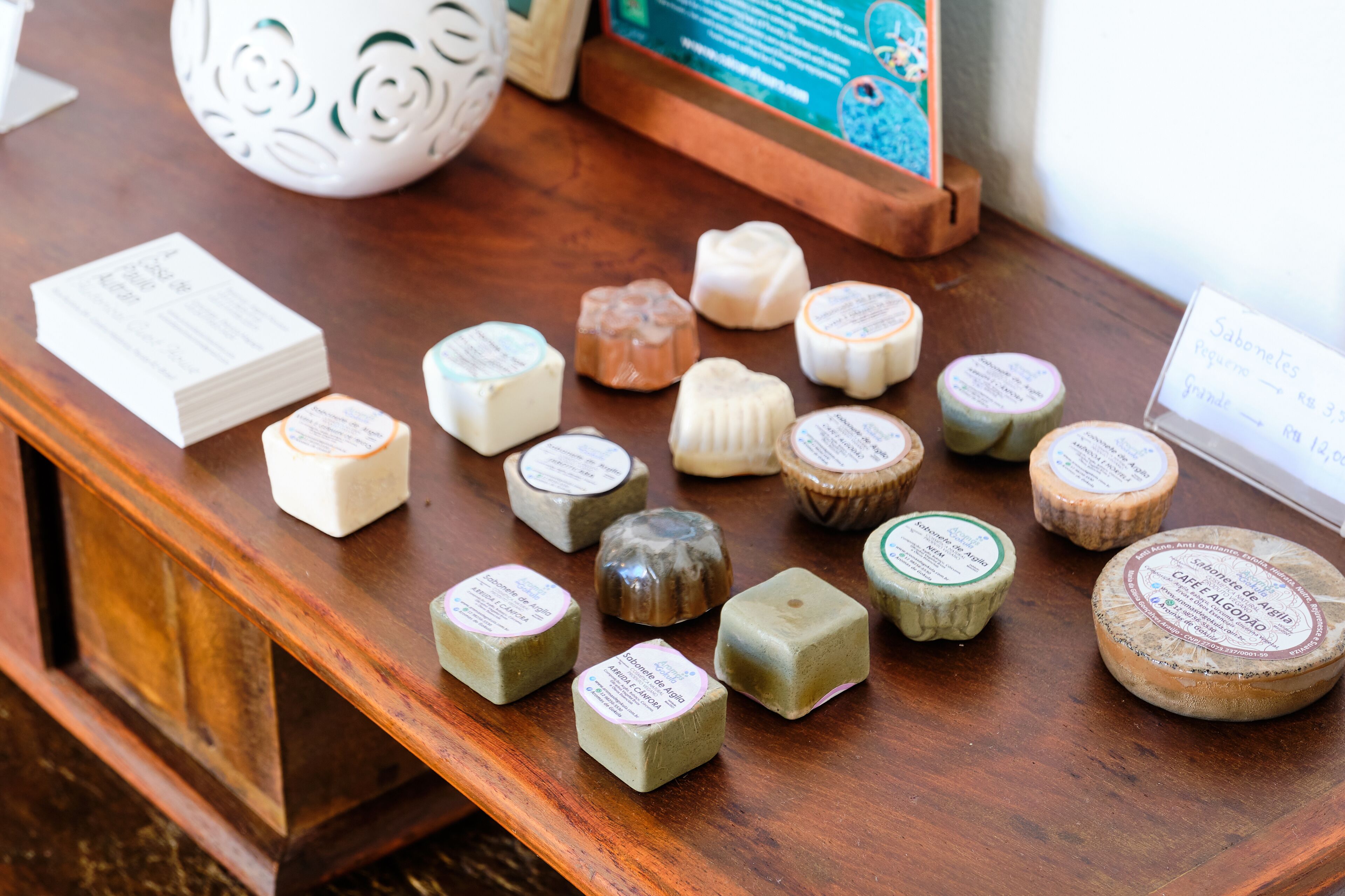 A wooden table displaying various cheese wheels with labels.