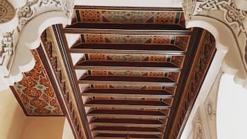 A spiral staircase with ornate carvings and a geometric pattern on the walls.