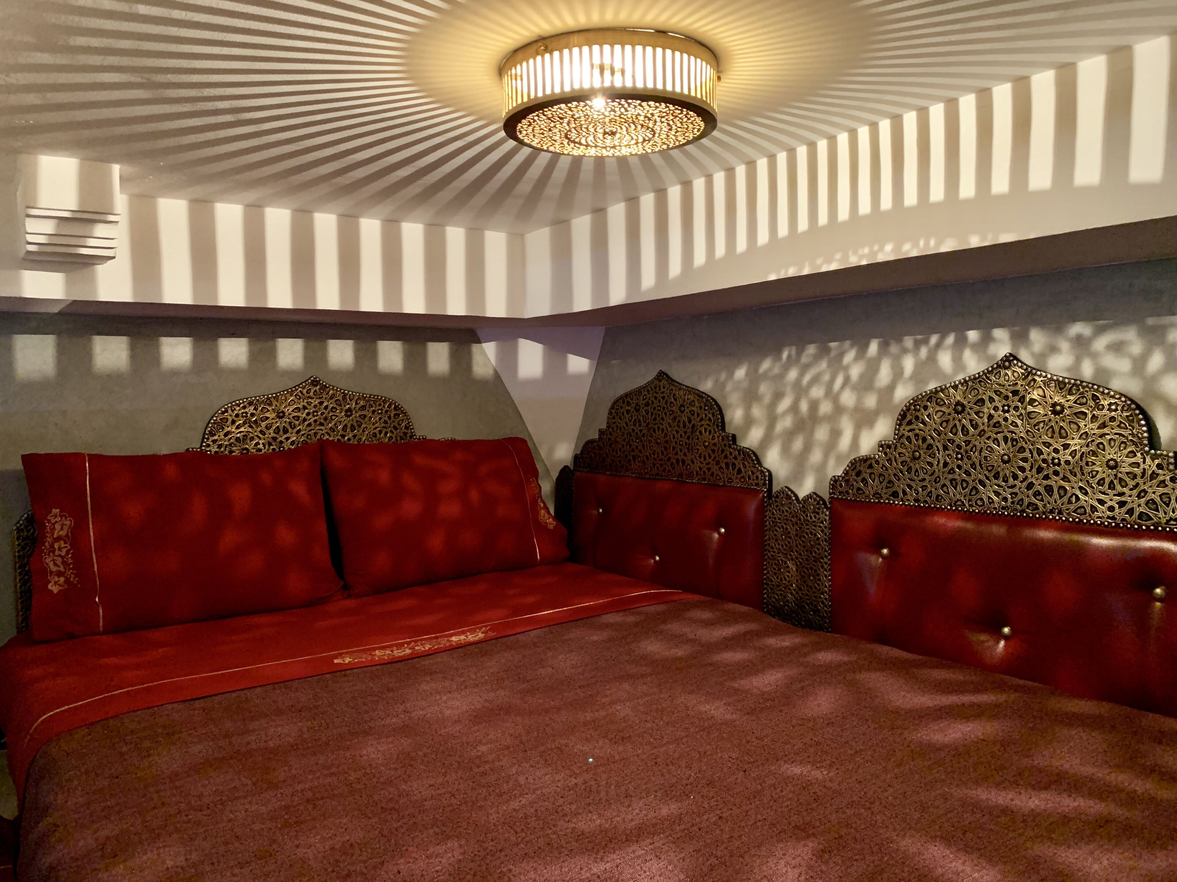 Une chambre à coucher avec un lit, un lustre et des têtes de lit à motifs.
