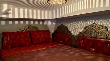Une chambre à coucher avec un lit, un lustre et des têtes de lit à motifs.