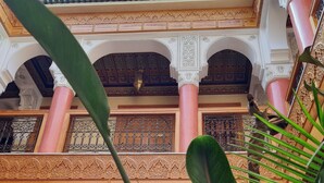 A multi-level atrium with ornate architectural details, including arches and columns, and a skylight above. - Riad Miral (Marrakech)