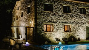 A stone building with a pool, outdoor seating, and a gated entrance. - Vila Caelus Masia Boutique (Rubió)