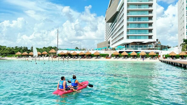 A modern hotel with a unique architectural design, featuring a large building with multiple balconies and a clear view of the ocean. - Hyatt Vivid Cancun Adults Only - All Inclusive  (Cancun)