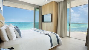 A hotel room with a large bed, a television, and a view of the ocean. - Hyatt Vivid Cancun Adults Only - All Inclusive  (Cancun)