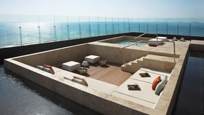 A rooftop pool area with a glass balustrade, lounge seating, and a view of the sea. - Hyatt Vivid Cancun Adults Only - All Inclusive  (Cancun)
