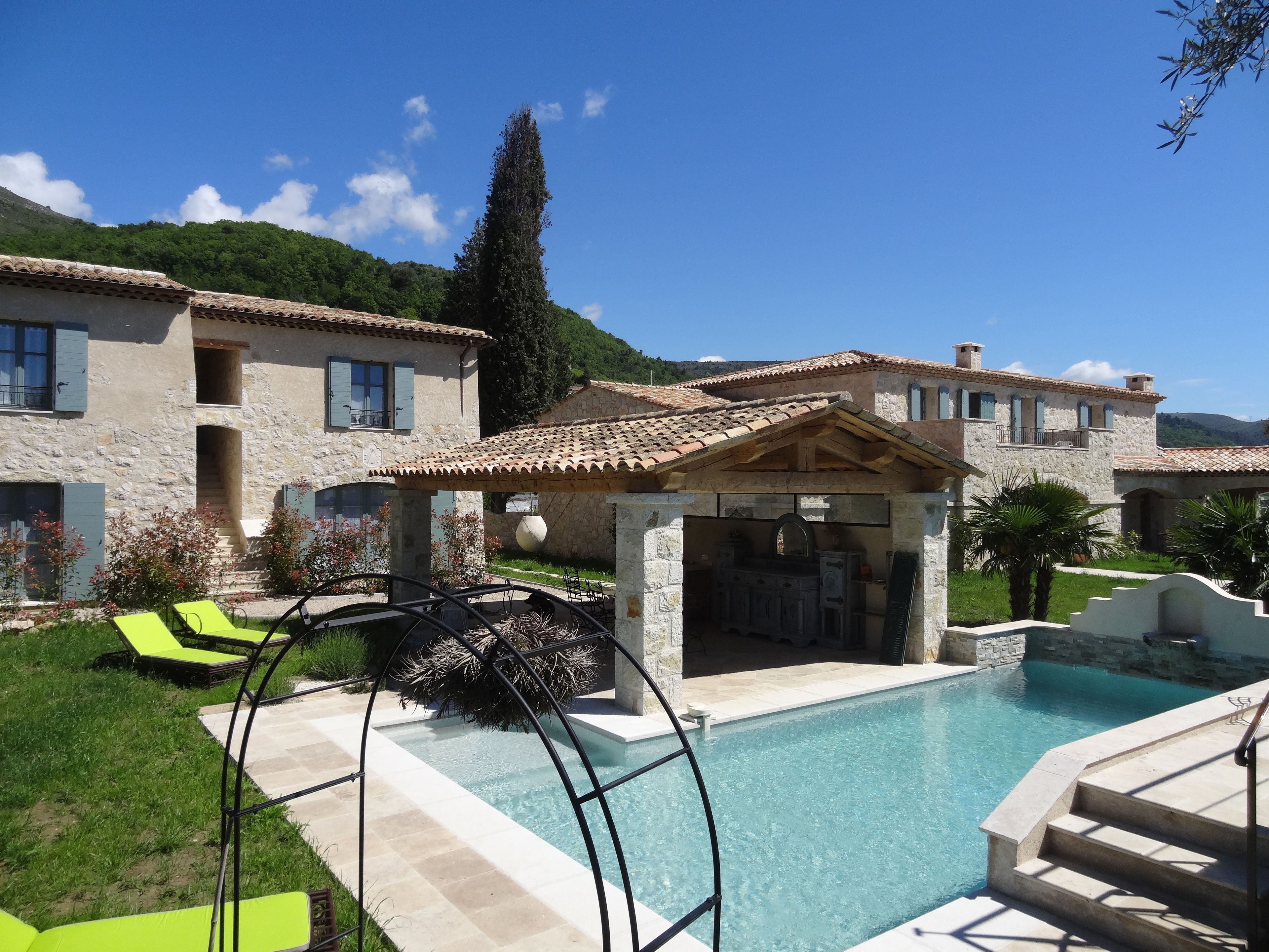 Een buitenzwembad, een infinitypool en ligstoelen