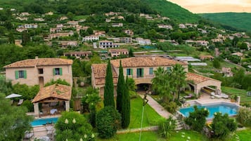 A residential area in South France with houses, a swimming pool, and lush greenery.