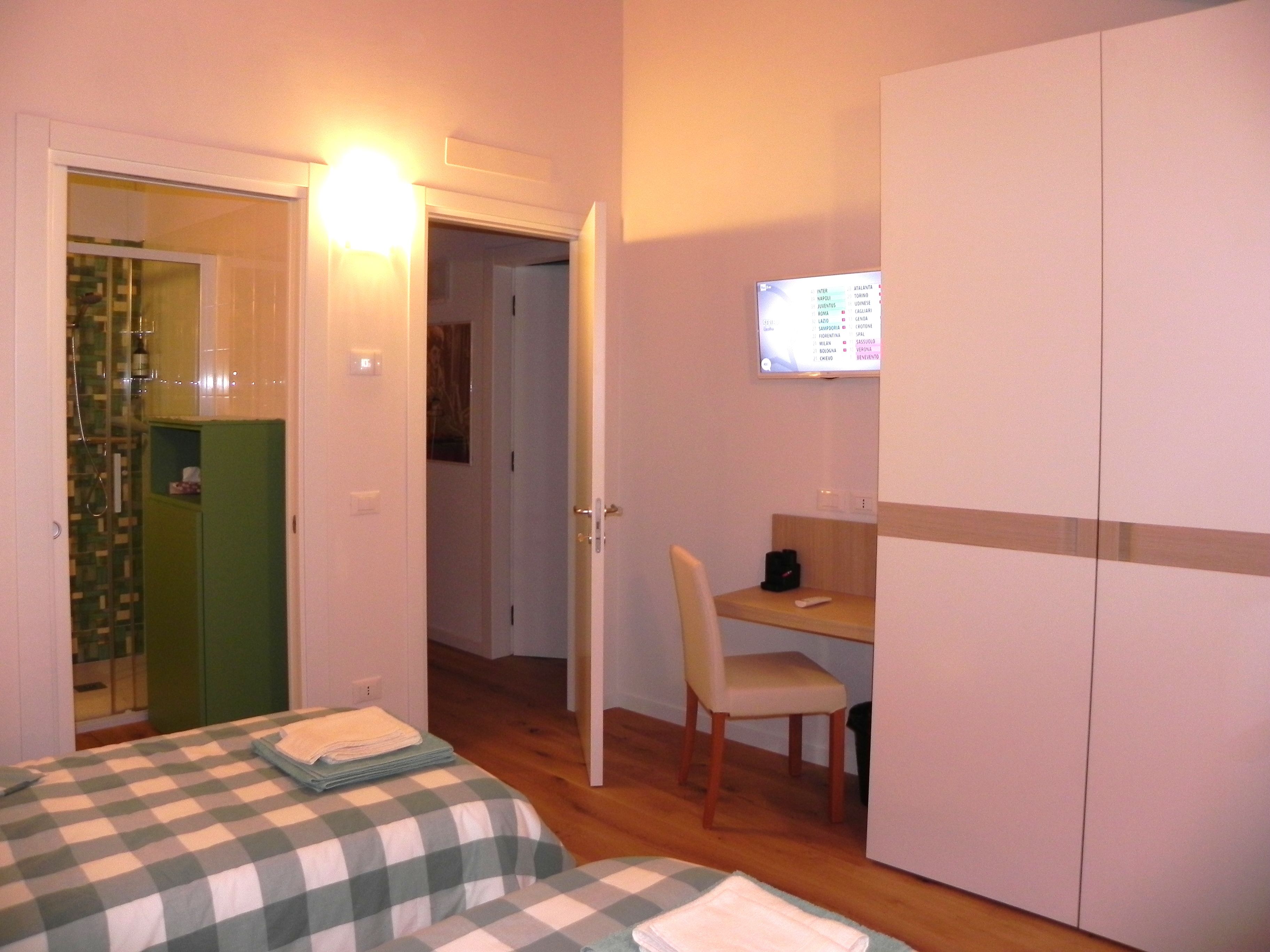 Une chambre d’hôtel comprenant un lit, un bureau, une chaise et une armoire.