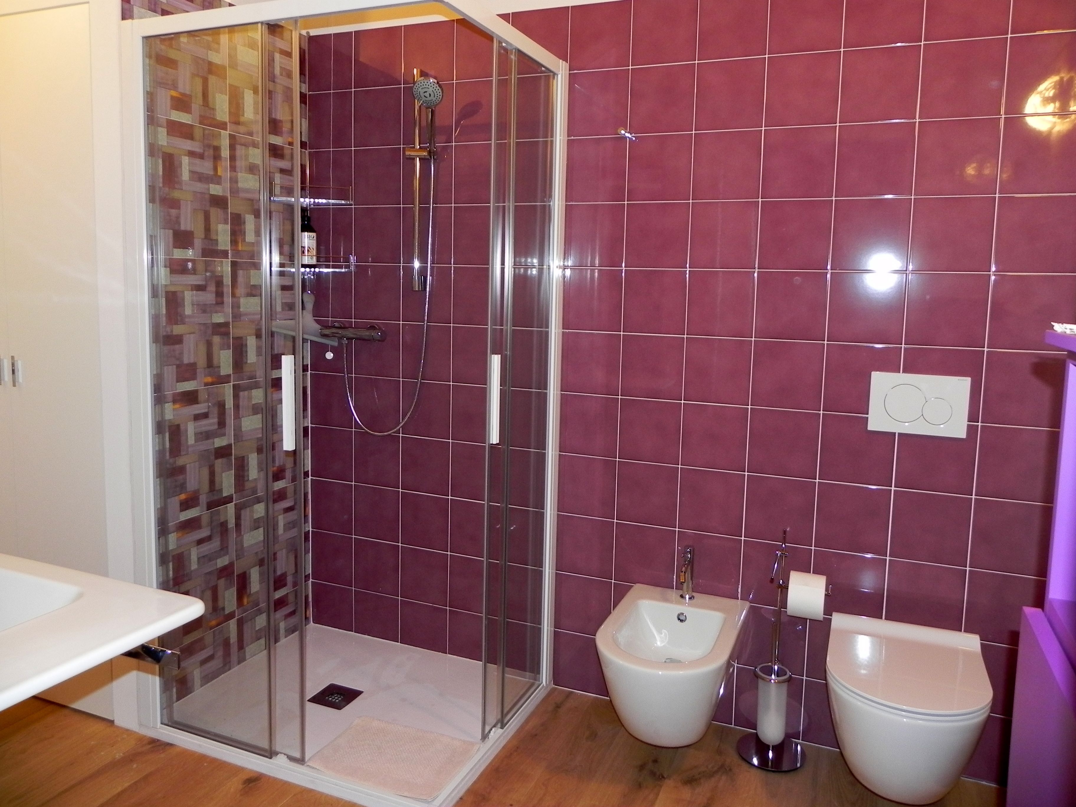 A bathroom with a glass-enclosed shower, a bidet, and a toilet.