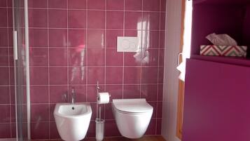 A bathroom with two sinks, a toilet, and a shower.