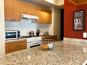 Departamento Confort, vista al jardín | Cocina privada | Refrigerador con congelador, microondas, horno y parrilla de estufa 