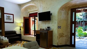 Een hotelkamer met een bed, een bureau, een televisie en uitzicht.