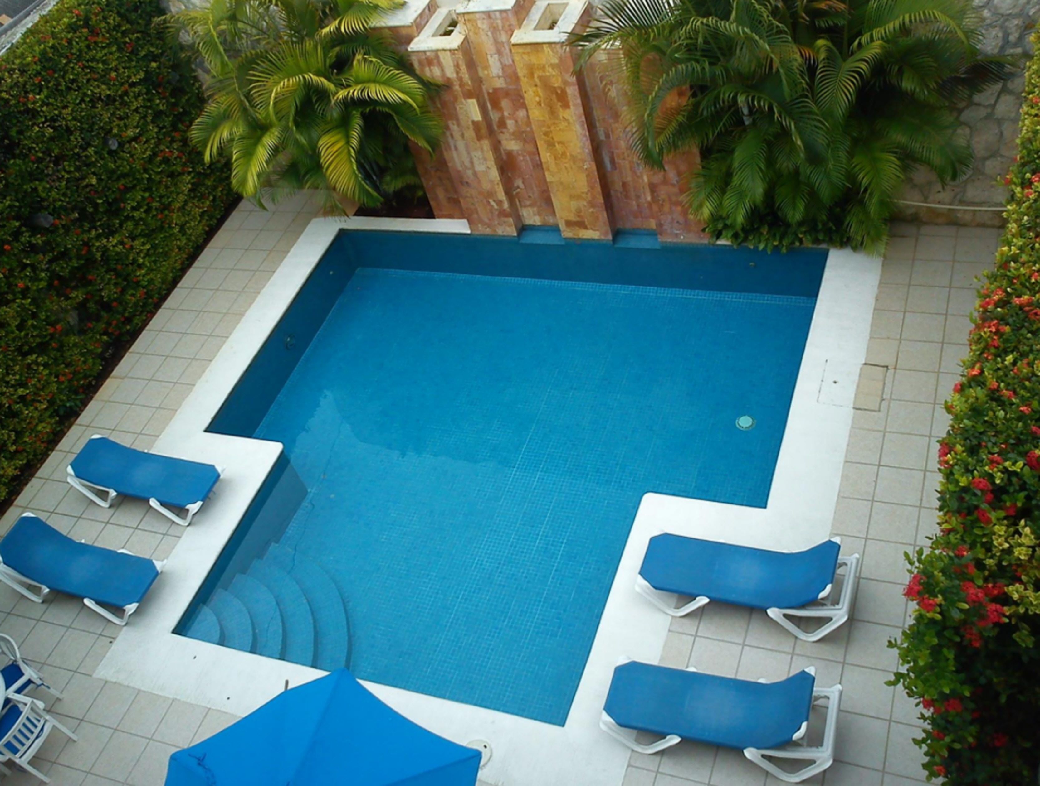 Alberca al aire libre y camastros 