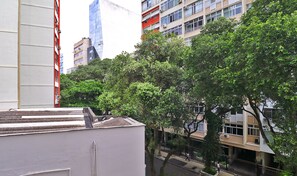 Eine Stadtansicht mit modernen Gebäuden, einer von Bäumen gesäumten Straße und blauem Himmel.