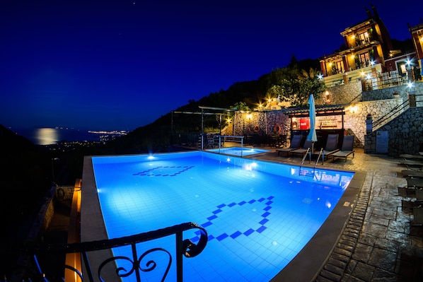 Una piscina al aire libre de temporada, sombrillas