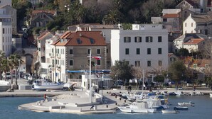 A coastal town with a marina, buildings with red-tiled roofs, and a mix of residential and commercial structures. - Villa Daky (Split)