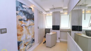 Un interior moderno con un cuadro abstracto grande, un mostrador de recepción y un separador de vidrio.