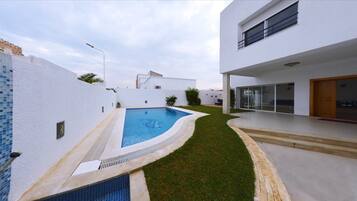 Kolam renang outdoor, dengan payung kolam renang dan kursi berjemur